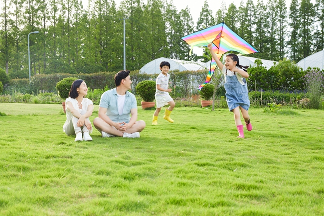 摄图网_501626119_年轻夫妻看着孩子追逐玩风筝（企业商用）.jpg