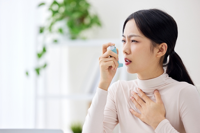 摄图网_506952961_室内生病使用哮喘喷雾的职场女性（企业商用）.jpg