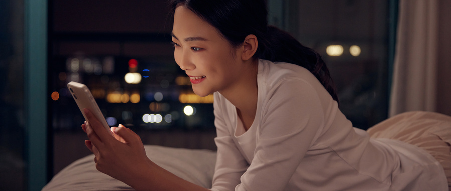 摄图网_501757242_wx_青年女性深夜睡前躺床上玩手机（企业商用）.jpg